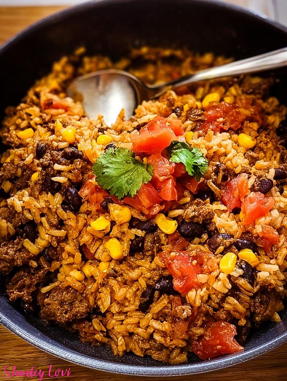 Delicious Mexican Beef Rice Skillet topped with melted cheese, fresh cilantro, and cherry tomatoes